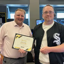 male in white socks jersey presented with an award for telecommunicator of the year.