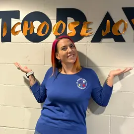 female in blue uniform sweater under signage that reads, "Today, I choose joy."